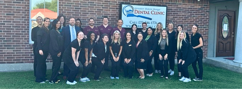 Dental clinic staff posing outside building.